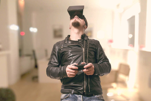 man wearing VR glasses and playing in virtual reality simulation at home - Фото, зображення