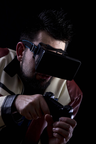 gamer man wearing vr glasses and using game joystick in darkness  - 写真・画像