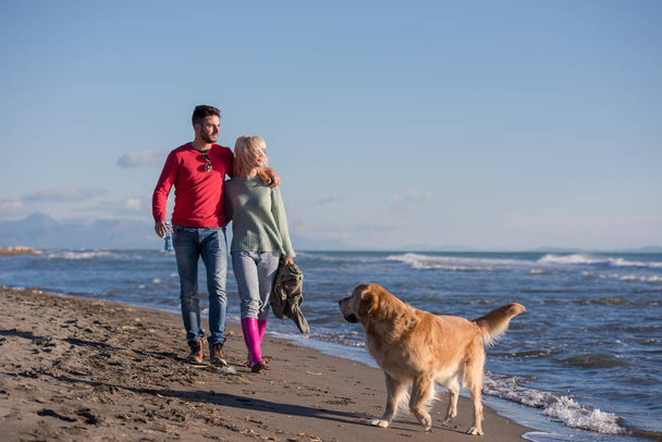Couple Running On The Beach Holding Their Hands with dog On autmun day - Φωτογραφία, εικόνα