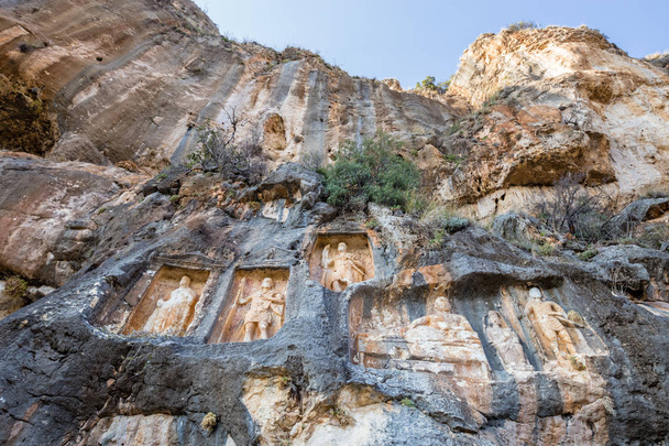 Fasada widok Adamkayalar, dosłownie oznacza człowieka skały, które znajduje się na szczycie góry Toros w Silifke, Mersin, Turcja. - Zdjęcie, obraz