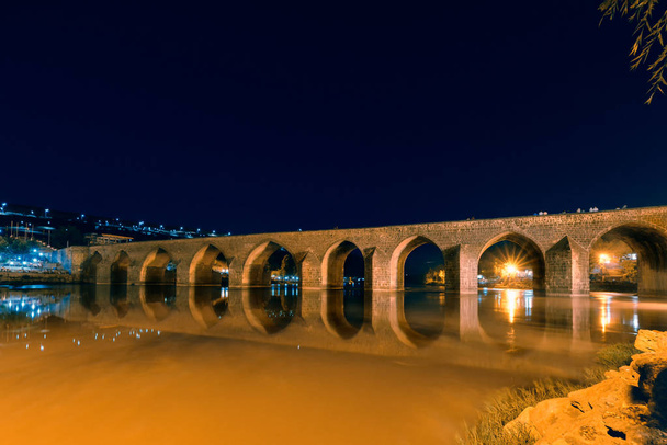 Nacht uitzicht op oude steen tien eyed brug, een populaire bezienswaardigheid in midden van Diyarbakir, Turkije. - Foto, afbeelding