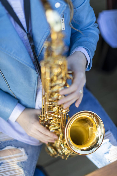 A person playing a lacquered saxophone - Foto, afbeelding