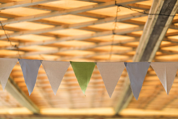 A colorful party banner hanging underneath a roof - Foto, Imagen