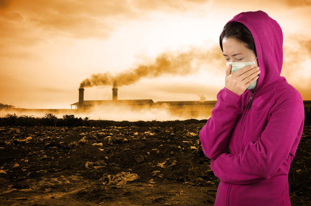 Жінка чхає, жінка одягнена в рожевий зимовий одяг в масці на обличчі на фоні забруднення повітря
 - Фото, зображення