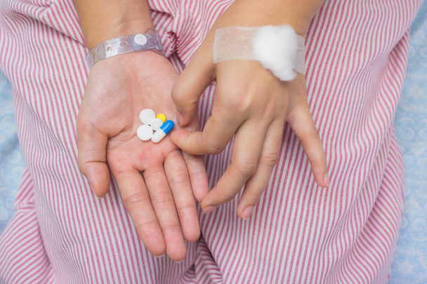 Θηλυκός ασθενής εκμετάλλευση κάψουλες στο χέρι σε δωμάτια νοσοκομείων. - Φωτογραφία, εικόνα