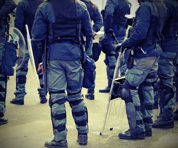 багато поліцейських у формі під час заворушень у місті з вінтажним ефектом
 - Фото, зображення