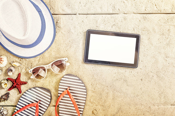 Καλοκαιρινές διακοπές σύνθεση. Σανδάλια, γυαλιά ηλίου, καπέλο, tablet και smartphone. αντιμετωπίσουν κάτοψη χώρου - Φωτογραφία, εικόνα