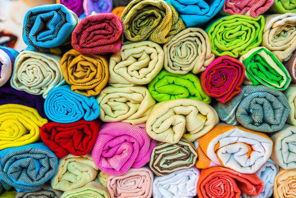 Composed Roll shaped stacked Traditional colorful silk ,cashmere head scarves or shawls and fabrics for sale in Grand Bazaar,Istanbul,Turkey - Photo, Image