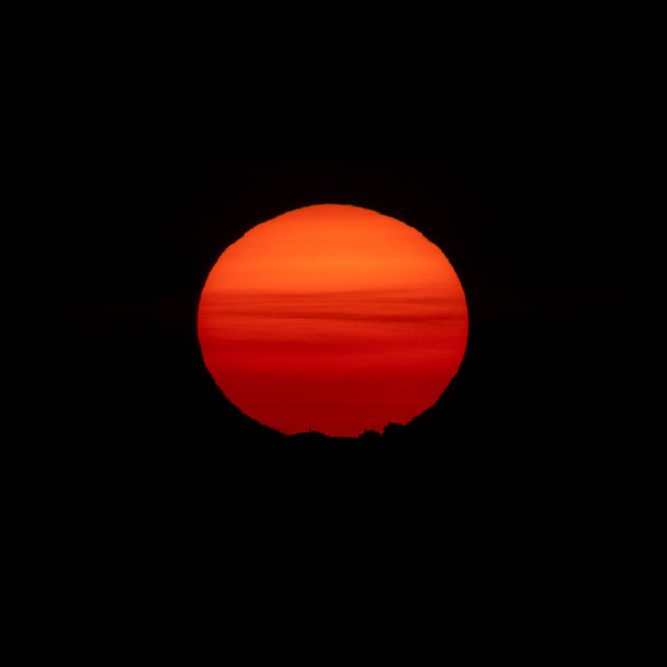 Sunrise over mountain peak with huge orange sun - Photo, Image