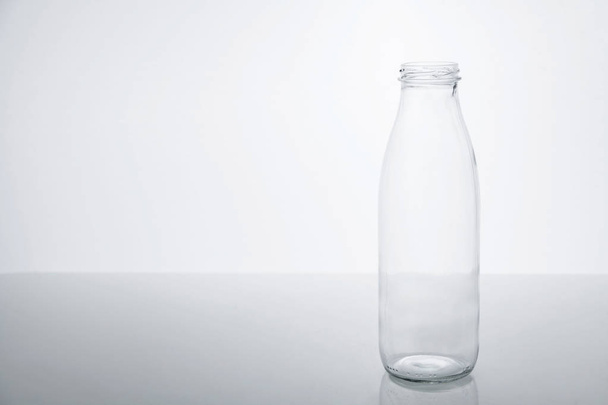Empty glass bottle on a white background. - Фото, изображение