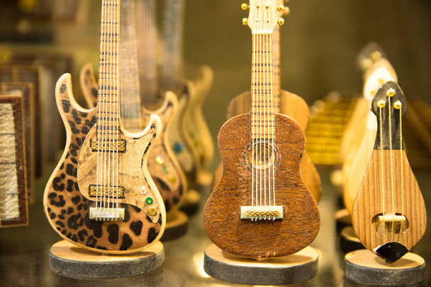 Muchas guitarras de juguete de madera coloridas clásicas colgando en la pared del showroom de la tienda, patrón de fondo en el gran bazar de Estambul
 - Foto, imagen