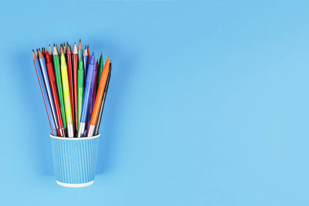 Minimalizmus. Fém tartó színes ceruzák a kék háttér. Concept iskolai, csendélet, másolja a hely. szemközti nézet. - Fotó, kép