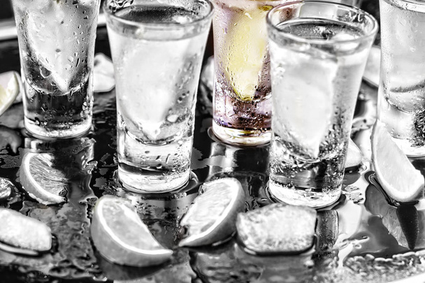 zwarte einde wit. Noir. Tequila shot met limoen en zeezout en ijs, selectieve aandacht. cocktail. wodka, gin, tequila met kalk. Close-up - Foto, afbeelding