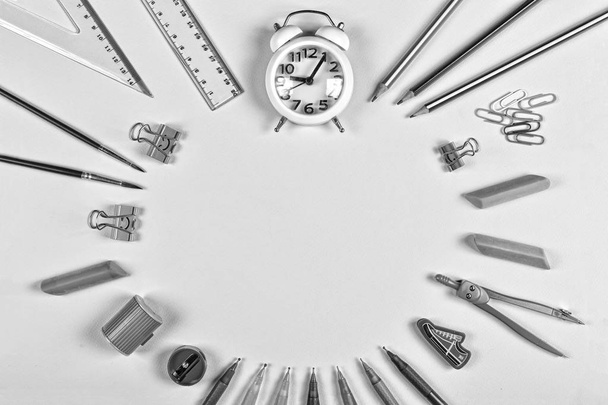 black and white. Back to school concept. minimalism. alarm clock and school supplies with copy space. Flat lay stylish set top view. - 写真・画像