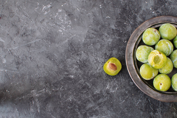 Delicious ripe green plums Greengages on ceramic black plate Black textured concrete background Autumn harvesting Flat lay Copy space - Fotografie, Obrázek