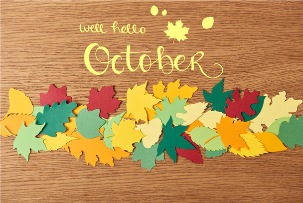vista dall'alto di colorato fogliame cartaceo con scritte "well hello ottobre" su sfondo di legno
 - Foto, immagini