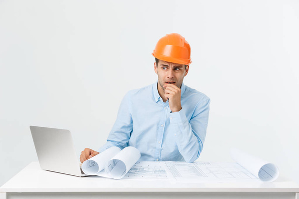 Serious man businessman or engineer sitting in construction site. Courageous middle aged man sit with sad,serious and depressed facial expression. - Photo, Image