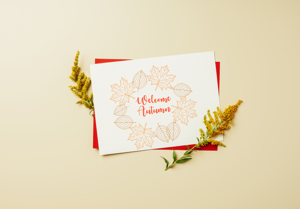 flat lay com de flores silvestres e cartão branco com letras "bem-vindo outono" em pano de fundo bege
 - Foto, Imagem