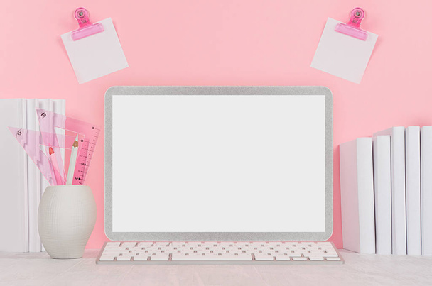 Elegant home workplace with stylish silver blank computer notebook and white stationery, stickers on pink background. - Фото, изображение