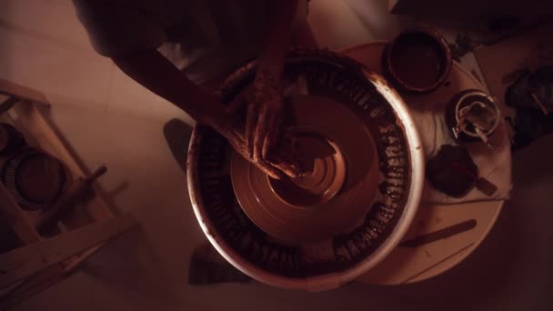 Proces utváření hliněné misky na rotující hrnčíři kola v temné světelné studio. - Záběry, video