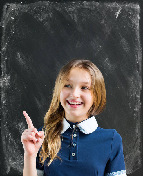 Retrato personagem adolescente aluno engraçado menina com uniforme escolar Sala de aula sujo turquesa quadro negro Fundo giz verde quadro-negro Conceito de educação
 - Foto, Imagem