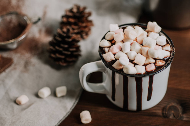 Hot chocolate with marsmallow candies, winter warming sweet drink in mug on wooden background, selective focus - Photo, image