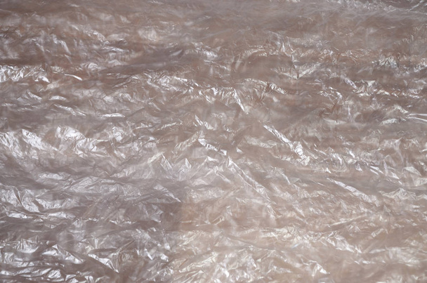 Texture di superficie di cellophane bianco accartocciato trasparente sulla luce solare. Concetto di materiali per l'imballaggio, protezione del prodotto contro i danni
 - Foto, immagini