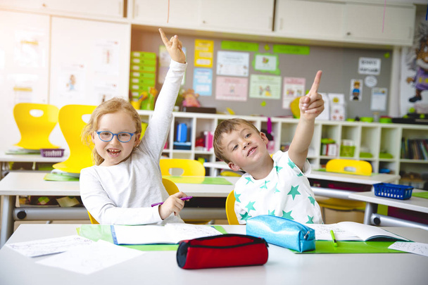 Beautiful young kids have fun in school while learning in classroom - Photo, image