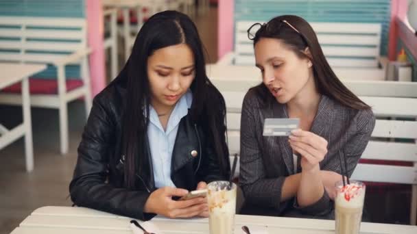 陽気な若い女性は、オンラインの銀行カード情報を入力ししており、インター ネット ショップでクレジット カードで払っています。近代的な技術とショッピング概念. - 映像、動画