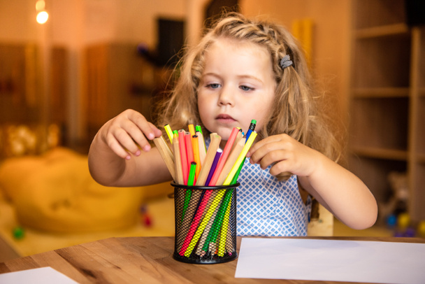 adorable child choosing felt tip pen for drawing in kindergarten - Photo, Image