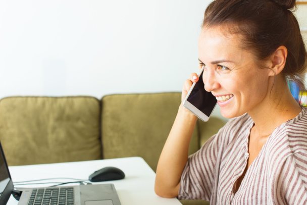 Gelukkig mooie jongedame praten telefoon zakenvrouw werken vanuit kantoor aan huis - Foto, afbeelding