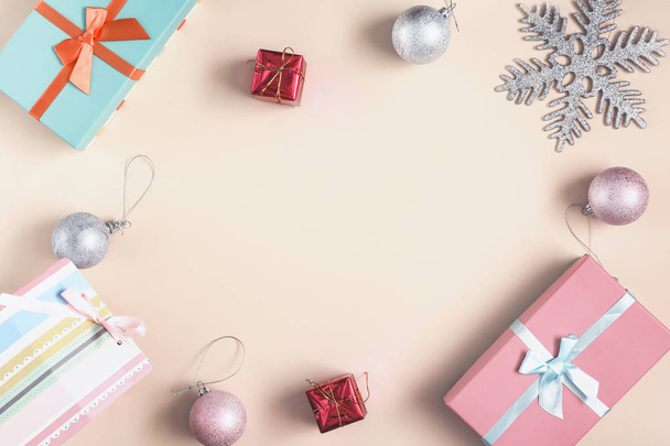 プレゼント、雪の結晶、クリスマス ボールと明るいベージュの背景. - 写真・画像