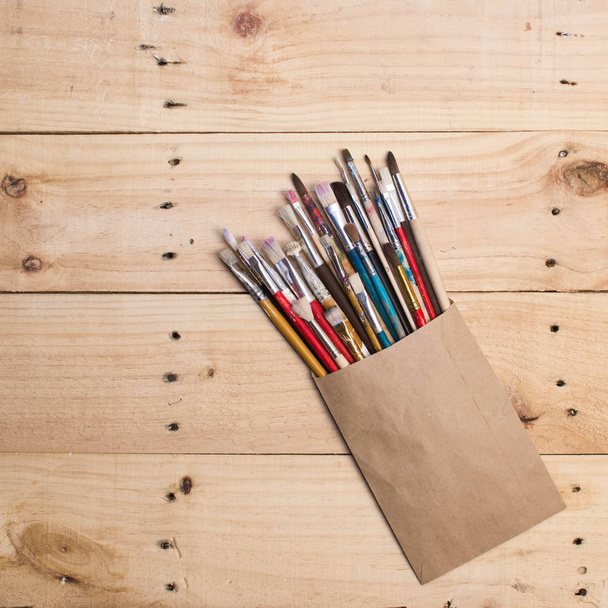 Brushes on the wooden background. The workplace of the artist. - Photo, Image
