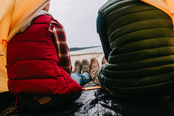 vue arrière du couple assis dans une tente de camping sur une plage de sable
 - Photo, image