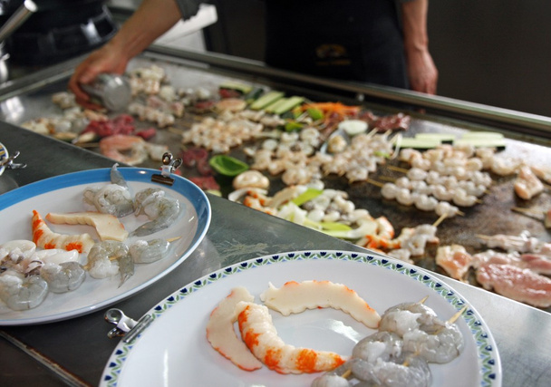 κινεζική μάγειρας, ενώ το ψήνει ψάρια λαχανικά και κρέας στο πιάτο - Φωτογραφία, εικόνα