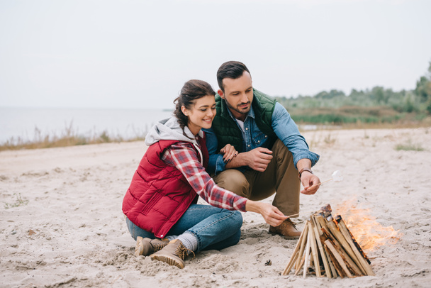 couple making campfire on sandy beach - Fotografie, Obrázek