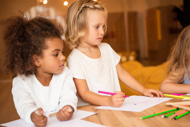 adorable multicultural friends drawing together in kindergarten - Φωτογραφία, εικόνα
