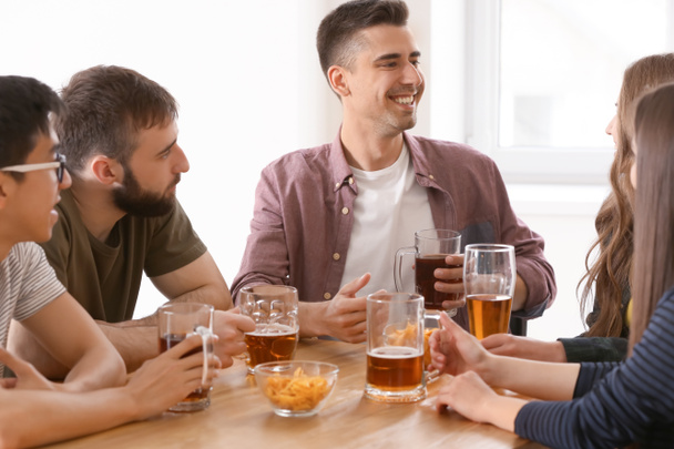 Group of cheerful friends drinking beer in bar - Фото, зображення
