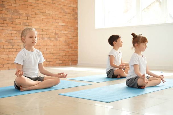 Niños pequeños practicando yoga en interiores
 - Foto, Imagen