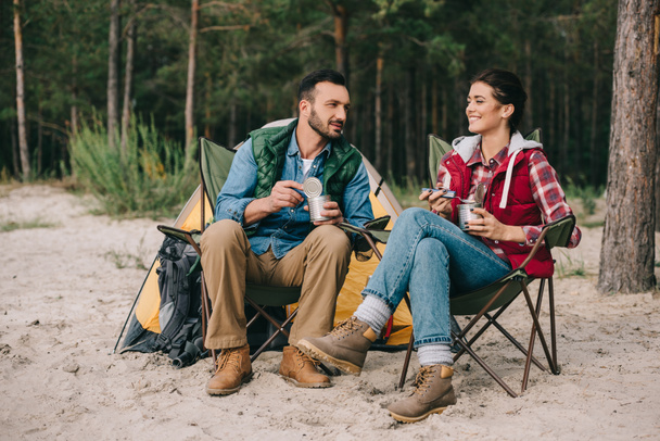 couple eating food from cans while having camping - Photo, Image