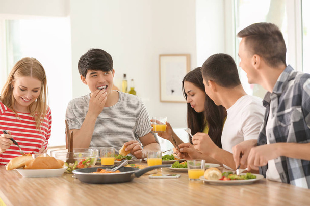 Amigos comiendo en la mesa en la cocina
 - Foto, Imagen