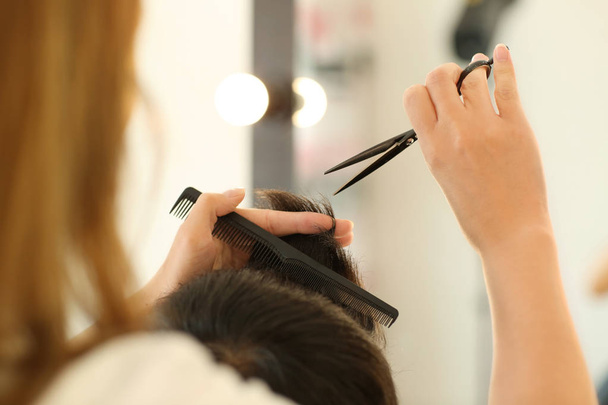 Professionele kapper werken met client in schoonheidssalon - Foto, afbeelding