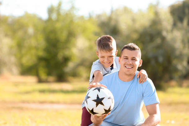 小さな男の子と屋外のサッカー ボールを持って彼のお父さん - 写真・画像