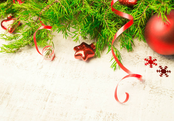 Christmas or New Year background: fir tree branches,  glass toys, decorations on a white wooden background. - 写真・画像
