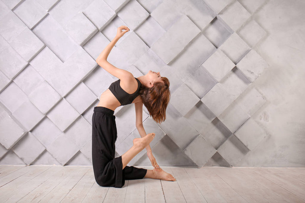 Sportieve vrouw die yoga binnen oefent - Foto, afbeelding