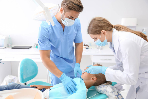 Dentista examinando dientes de niño en la clínica - Foto, imagen