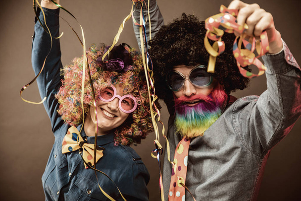 Happy man and woman wearing color wigs with party items - Foto, immagini