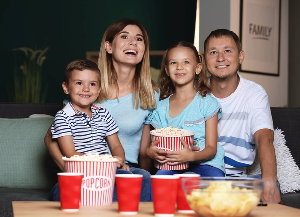 Ευτυχισμένη οικογένεια τρώνε ποπ κορν βλέποντας τηλεόραση βράδυ - Φωτογραφία, εικόνα