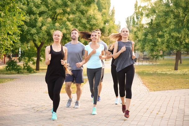 Ryhmä urheilullisia ihmisiä juoksemassa ulkona
 - Valokuva, kuva
