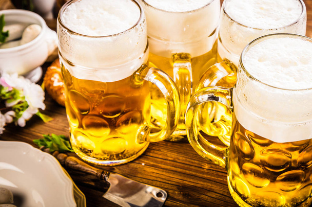 Oktoberfest beer, pretzels and various Bavarian specialties on wooden background - Foto, afbeelding